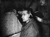 Prisoner of war, Lieutenant Peter Neave, using a hidden radio inside Oflag 79 in Braunschweig (also known as Brunswick), Germany.  Photograph taken between March and April 1944 by Captain Ian McD Matheson. Note on back of file print reads 
