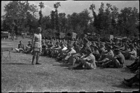 Brigadier Cyril Weir giving a farewell address to New Zealand artillerymen, at artillery headquarters near Arce, Italy, during World War 2. Shows Brigadier Weir addressing rows of troops seated outside on the grass. Photograph taken by George Robert Bull circa 16 Jun 1944.