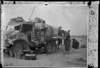 New Zealand artillery signallers in action during the advance into Tobruk, Libya, during World War 2. Shows a Ford military truck and men working alongside. Photograph taken in Egypt circa 20 December 1941.