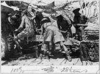 New Zealand soldiers of 5th Field Regiment near Alum Nyal, Ruweisat, Egypt during World War 2. Shows six unidentified men under a camouflage net, loading a 25 pound gun.