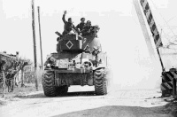 New Zealand tank moving through the front line village of Granarolo dell'Emilia, Senio River area, Italy, on the day of the bombing of the enemy defences beyond the Senio River. Photograph taken by George Kaye on 9th April 1945.