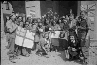 Italian women of the newly liberated town of Massa Lombarda holding flags of the Allied Nations which they have ready to past in various parts of the town. Massa Lombada fell to New Zealand troops the previous evening.  Photographed by George Kay on the 13th of April, 1945.
