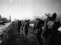 21 New Zealand Battalion moving along the Via Emilia in Italy to relieve the Maori Battalion. The ememy held Castel Bolognese is about 2000 yards distant. Photograph taken by George Kaye on the 9th of January 1945.