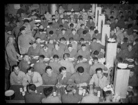 New Zealand soldiers of the 2nd Echelon in a mess area, on board a troopship during WW2. Possibly 3rd section, 4 Reinforcements en route to Egypt on the ship Nieuw Amsterdam. Shows rows of men seated at tables.  Photograph taken circa 1940.
